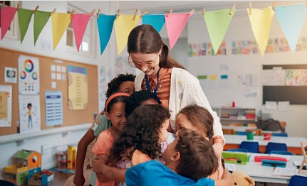 Niños abrazando a su docente en un aula