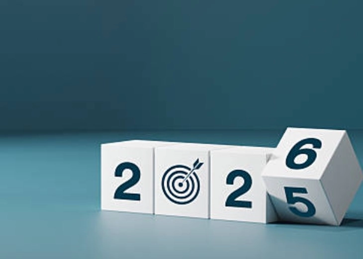 Cubos blancos con los números 2025 y 2026 sobre fondo azul, representando el cambio de año.